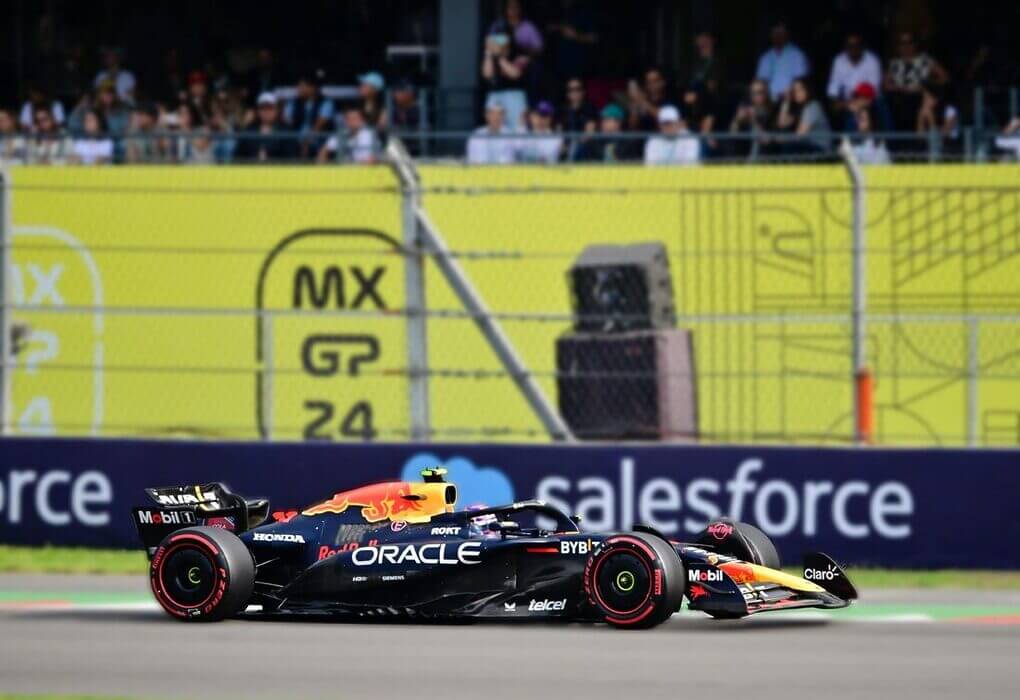 Dynamic shot of an F1 car racing at Mexico City Grand Prix with a cheering crowd in the background.