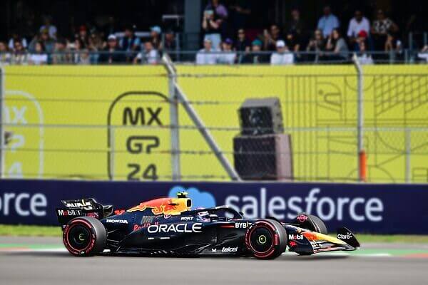 Dynamic shot of an F1 car racing at Mexico City Grand Prix with a cheering crowd in the background.