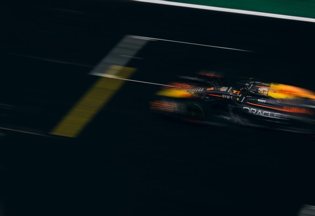 Blurred image of a Formula One car racing down the track, showcasing speed and motion.