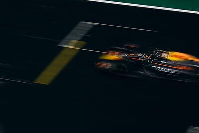 Blurred image of a Formula One car racing down the track, showcasing speed and motion.
