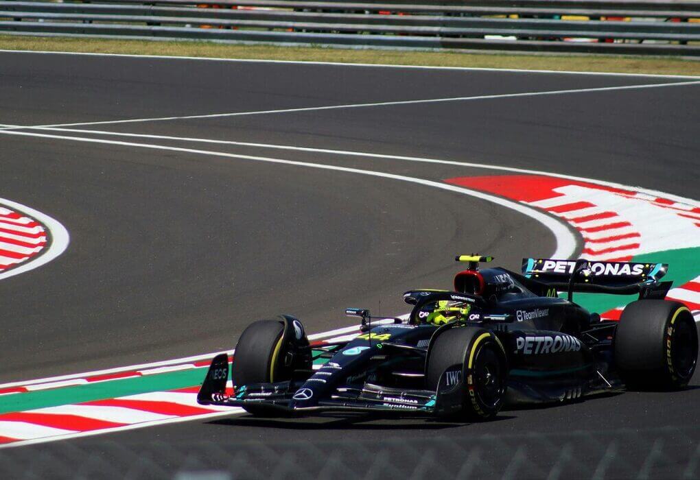 Dynamic shot of a Formula 1 car speeding around a track curve, showcasing motorsport excitement.