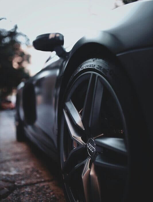 Close-up shot of a sleek, modern luxury sports car wheel with focus on design and details.