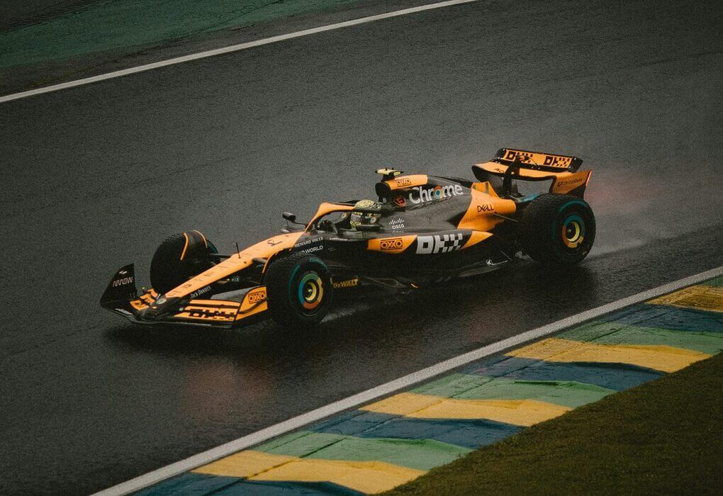 A Formula 1 car speeds around a wet track during an intense race, highlighting precision and speed.