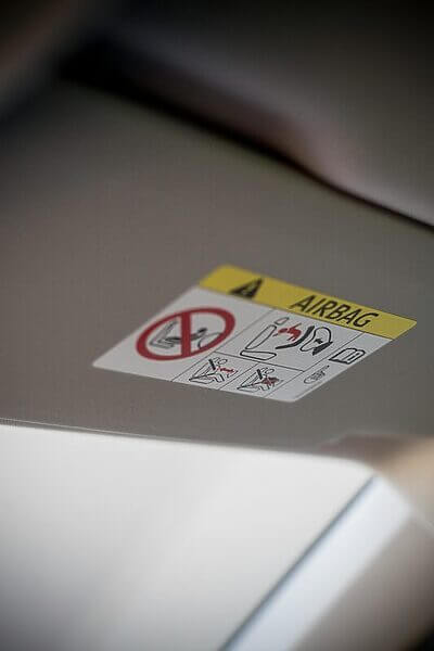 Detailed close-up of a car airbag warning sign on a vehicle interior panel.