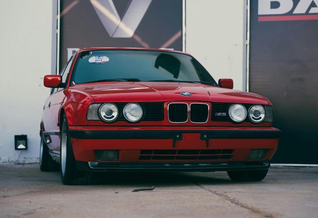 Front view of a vintage red BMW M5 E34 parked outdoors in Benghazi, Libya.