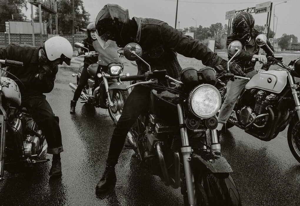 Group of motorcyclists riding on a wet street showcasing dynamic and adventurous vibe.