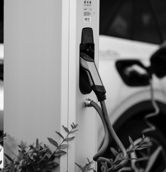 Monochrome image of an electric vehicle charging station in an urban setting.