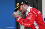 Lewis Hamilton en combinaison Ferrari célébrant sa victoire sur le podium de Barcelone