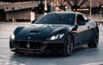 Une Maserati devant un site industriel Stellantis en Italie.