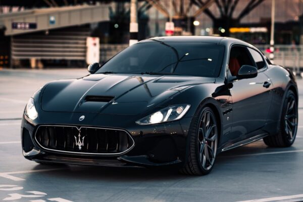 Une Maserati devant un site industriel Stellantis en Italie.