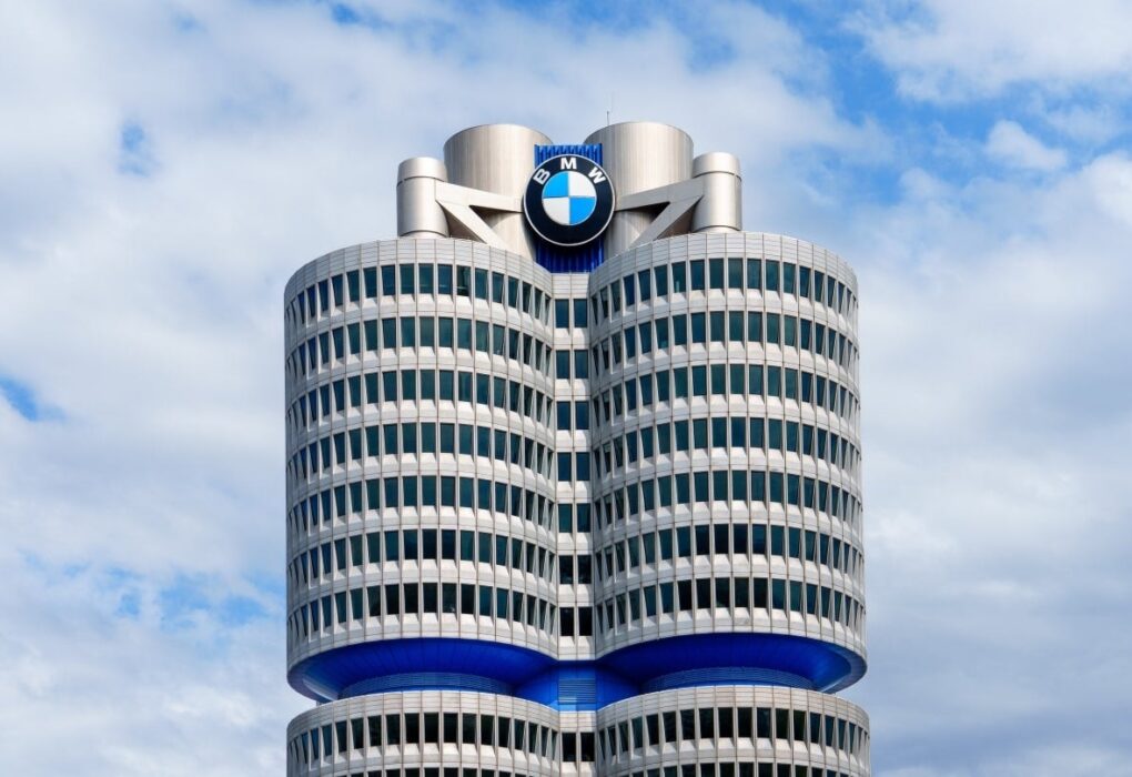 Logo BMW sur un bâtiment du constructeur allemand dans un contexte de discussions sociales et financières.