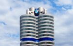 Logo BMW sur un bâtiment du constructeur allemand dans un contexte de discussions sociales et financières.