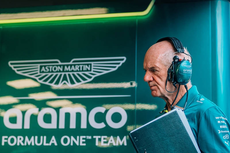 Adrian Newey dans le garage Aston Martin F1 près de la monoplace 2026.