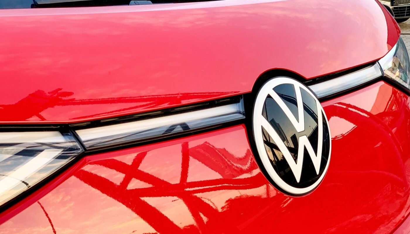 Des modèles Volkswagen alignés devant une usine du groupe lors d’une présentation industrielle.