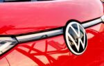 Des modèles Volkswagen alignés devant une usine du groupe lors d’une présentation industrielle.
