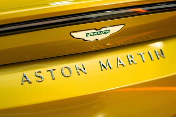 Une Aston Martin récente photographiée devant un bâtiment, symbole des tensions financières autour du constructeur britannique.