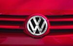 Un Volkswagen ID.4 devant le logo du constructeur allemand.