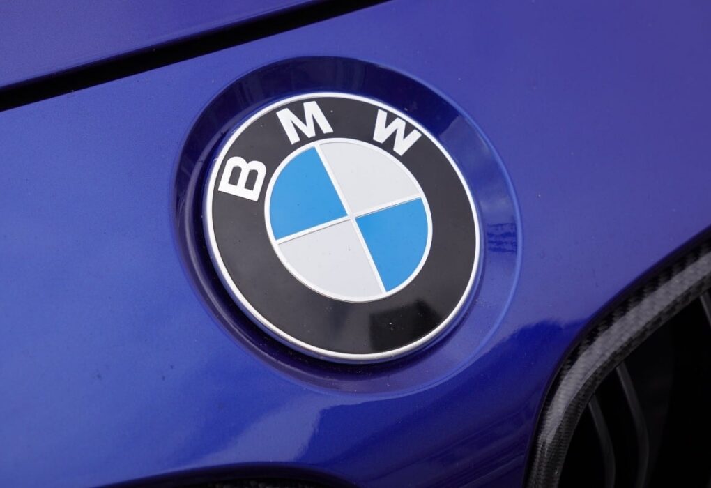Des voitures BMW alignées devant un bâtiment du constructeur allemand.