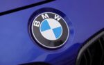 Des voitures BMW alignées devant un bâtiment du constructeur allemand.