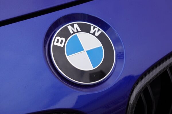 Des voitures BMW alignées devant un bâtiment du constructeur allemand.