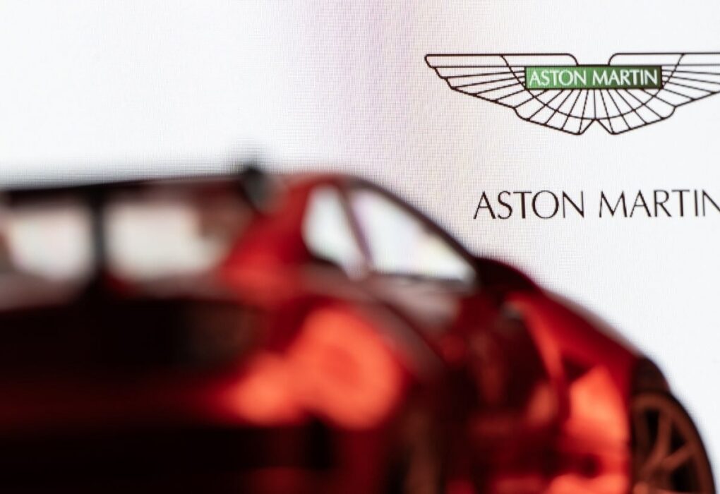 Une Aston Martin devant le logo du constructeur automobile britannique.