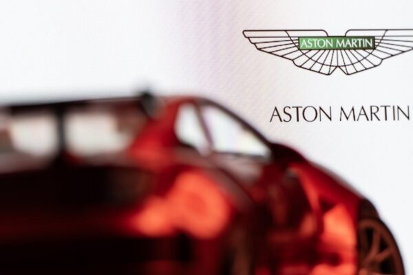 Une Aston Martin devant le logo du constructeur automobile britannique.