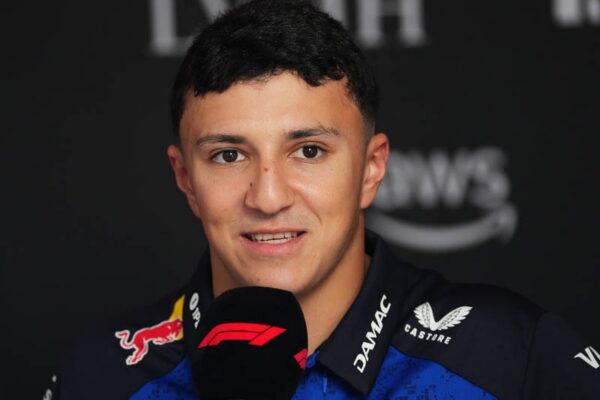 Isack Hadjar en tenue de pilote dans le paddock de Formule 1.