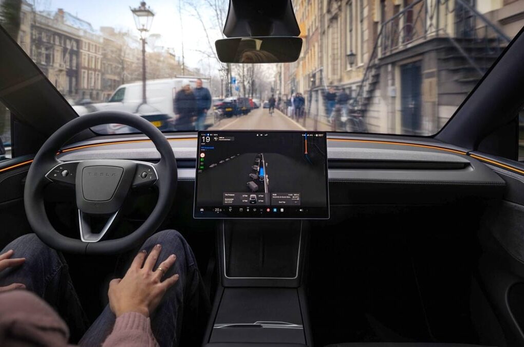 Une Tesla circulant sur route avec le système de conduite FSD actif à bord.