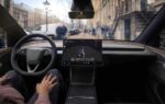 Une Tesla circulant sur route avec le système de conduite FSD actif à bord.