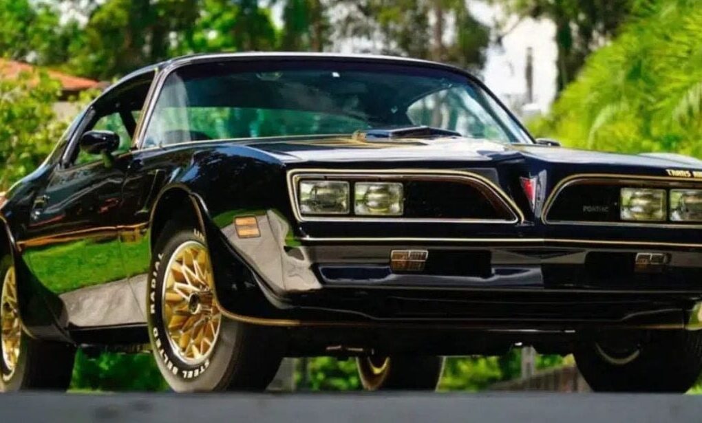 Une Pontiac Firebird Trans Am noire et dorée associée à Burt Reynolds et au film Cours après moi shérif.
