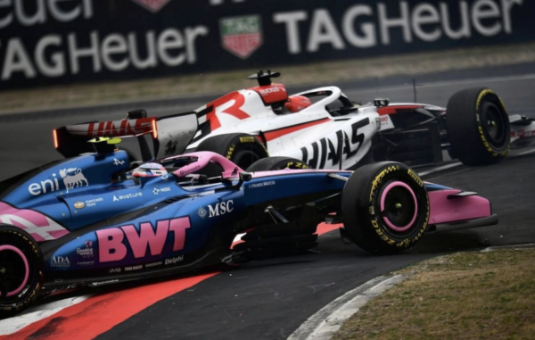 Une monoplace de Formule 1 aux couleurs roses de BWT en piste.