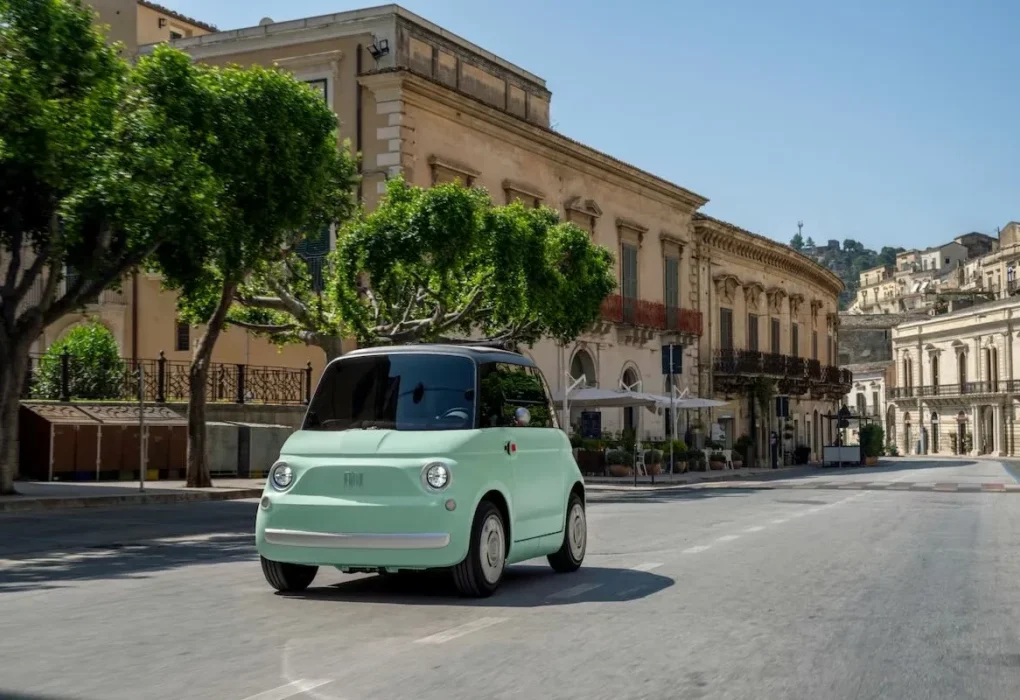 Fiat Topolino Dolcevita électrique avec sa capote en toile ouverte en ville.