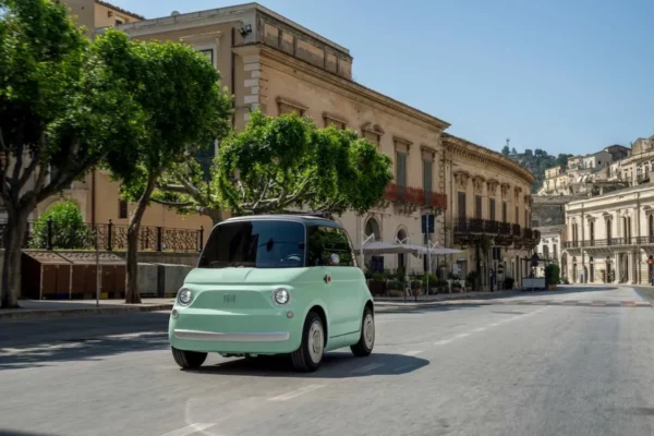 Fiat Topolino Dolcevita électrique avec sa capote en toile ouverte en ville.