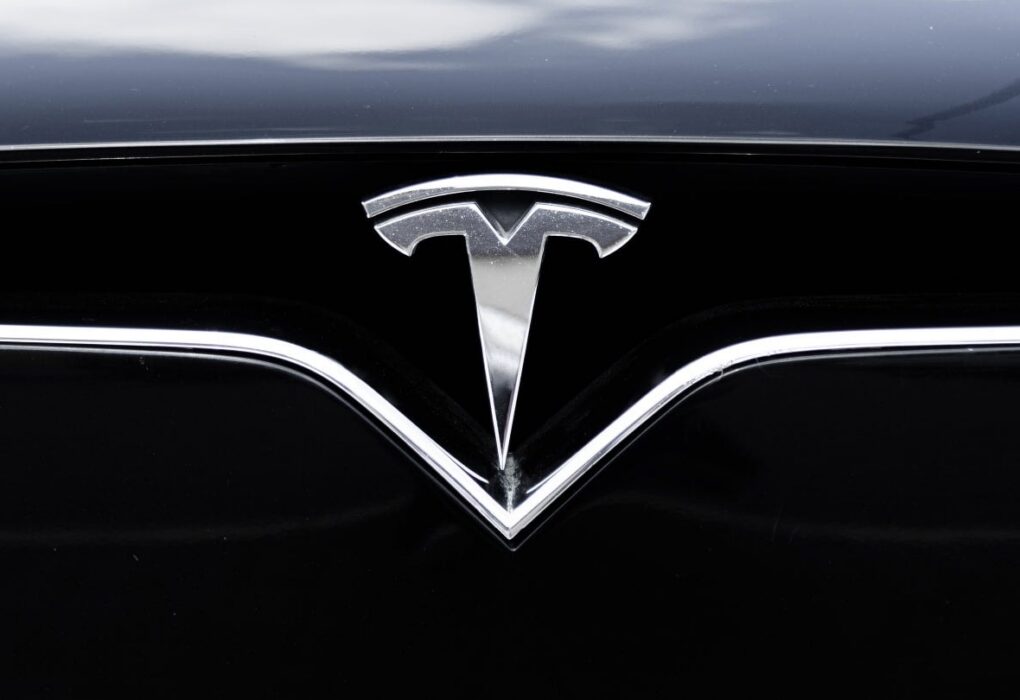 Une Tesla circule sur une route urbaine avec le système d’assistance FSD Supervised activé.