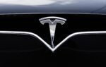 Une Tesla circule sur une route urbaine avec le système d’assistance FSD Supervised activé.