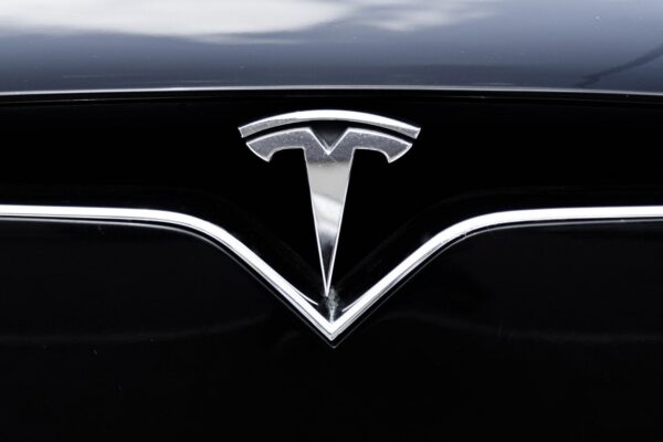 Une Tesla circule sur une route urbaine avec le système d’assistance FSD Supervised activé.