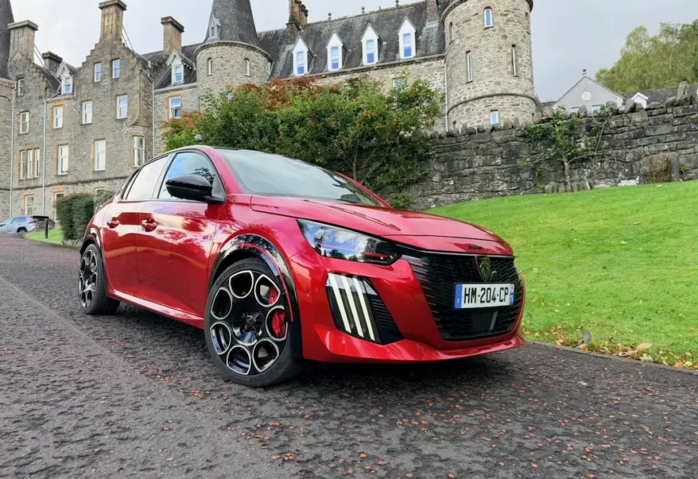Peugeot e-208 GTI rouge avec ses jantes de 18 pouces et ses élargisseurs d’ailes.