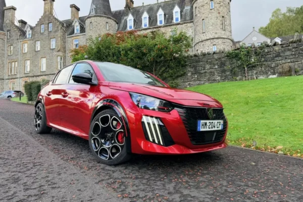 Peugeot e-208 GTI rouge avec ses jantes de 18 pouces et ses élargisseurs d’ailes.
