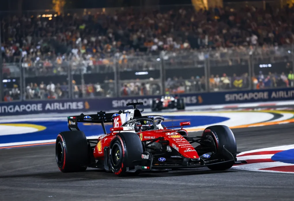 Une Ferrari SF-26 en piste, avec ses pontons et son fond plat visibles de profil.