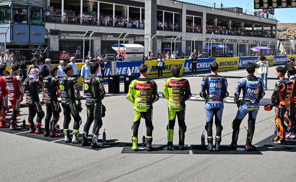 Des pilotes de MotoGP réunis dans le paddock lors d’un Grand Prix.