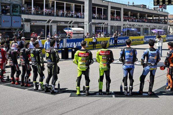 Des pilotes de MotoGP réunis dans le paddock lors d’un Grand Prix.